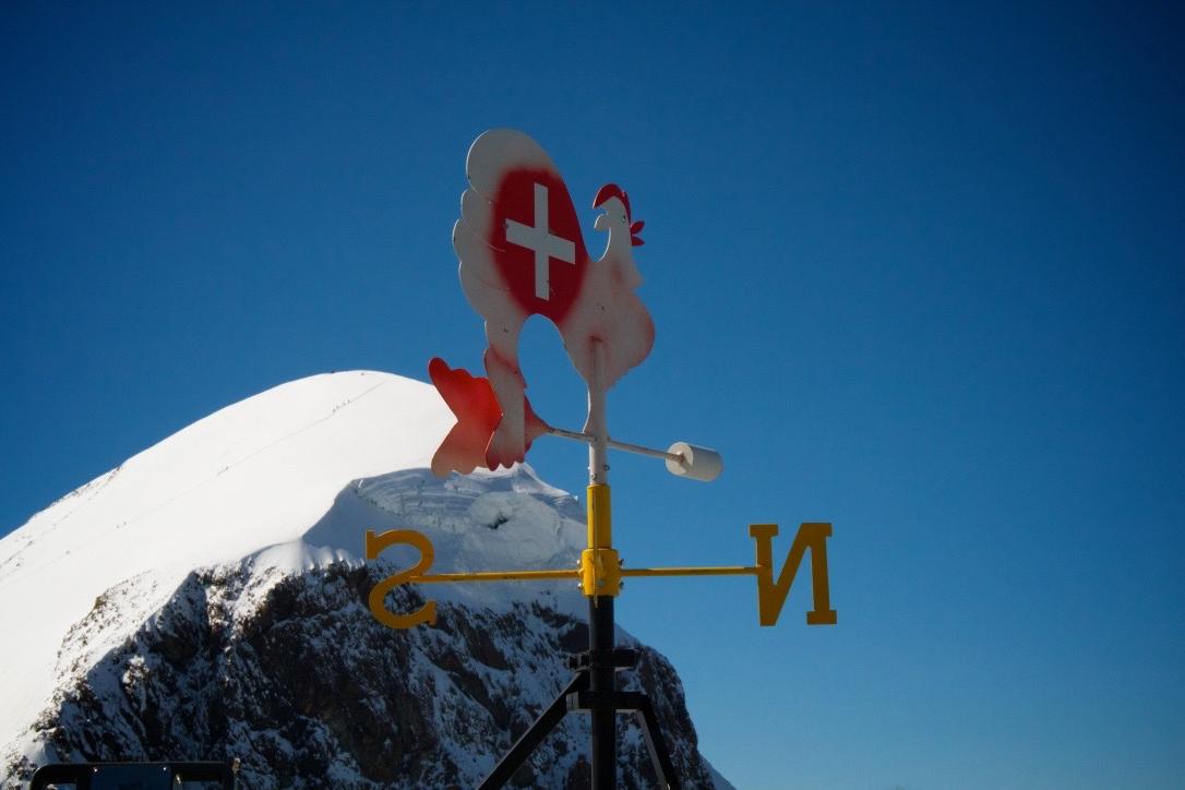 Peak of mountain top with weather vane in foreground